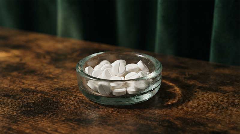 White pills in a glass dish, representing the statin and CoQ10 conversation