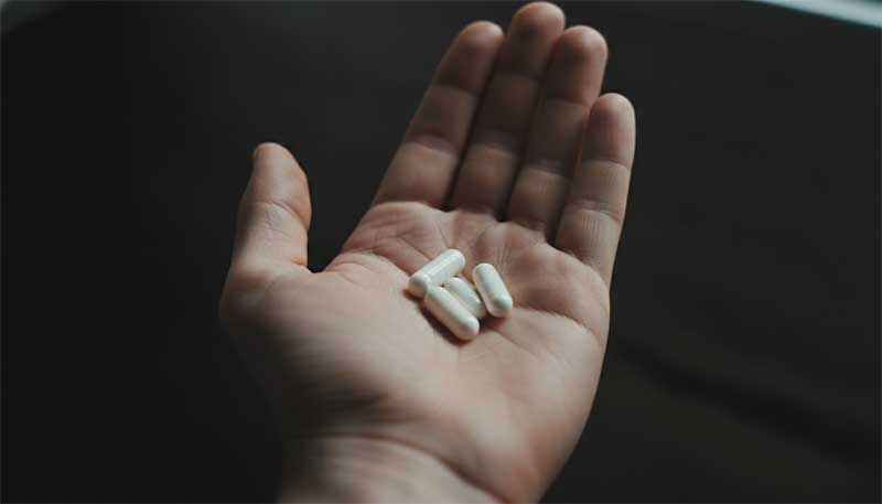 Supplement capsules on dark background