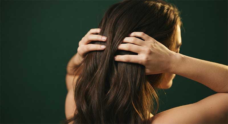 Hands running through healthy, thick hair